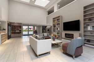 a living room with a couch and chairs and a tv at Hawthorn Extended Stay by Wyndham Ft Lauderdale Cypress Crk in Fort Lauderdale