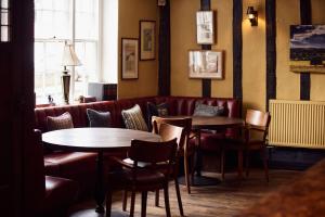 a restaurant with two tables and chairs and a couch at The Sun Inn in Dedham