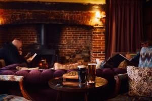 a living room with a couch and people in a fireplace at The Sun Inn in Dedham