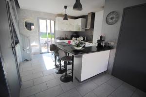 a kitchen with a counter and a table with stools at Maison - Proche RER - Jusqu'à 6 Personnes in Saint-Michel-sur-Orge