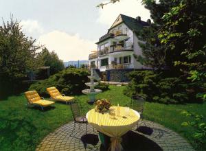 a house with a table and chairs and a fountain at Haus Marientaler Au GbR in Zell an der Mosel