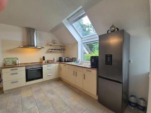 Una cocina con refrigerador de acero inoxidable y ventana. en Stilvoll am Wald wohnen 115 qm Office citynah, en Stockstadt am Main