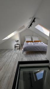 una camera da letto mansardata con un letto e una finestra di vetro di Villa Rasmus a Kołobrzeg