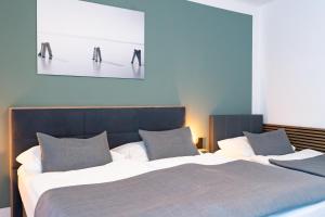 a bedroom with two beds and a painting on the wall at Kracher Hotel Doppelzimmer - für maximal 4 Personen inklusive Pool in Illmitz