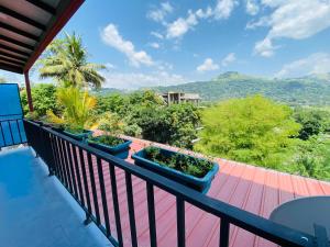 ein Balkon mit Blick auf Bäume und Berge in der Unterkunft TK Homes in Badulla