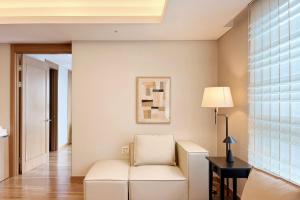 a living room with a white chair and a lamp at Gyeongbokgung Palace View, 3-min Walk to Gwanghwamun & Jonggak Stations in Seoul +49 photos