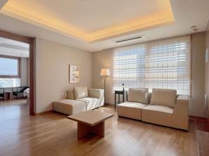 a living room with two couches and a table at Gyeongbokgung Palace View, 3-min Walk to Gwanghwamun & Jonggak Stations in Seoul