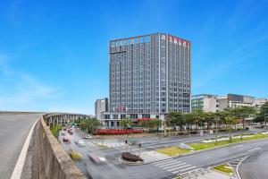 una città con un palazzo alto e una strada con le auto di Foshan Jifeng International Hotel a Foshan