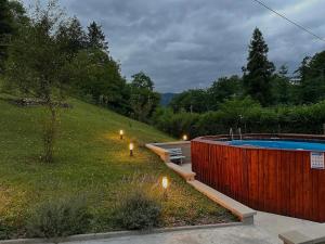 a backyard with a pool and a yard with lights at Holiday House Provance in Brod na Kupi