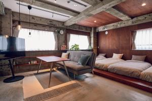 a room with a bed and a couch and a table at Koubanoyado in Tokyo