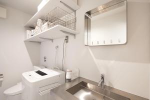 a white bathroom with a sink and a mirror at Koubanoyado in Tokyo +21 photos