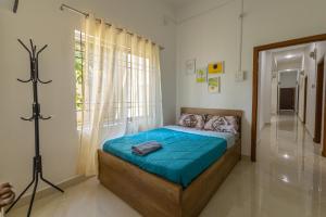 a bedroom with a bed with blue sheets and a window at Hostello Backpackers in Dibrugarh