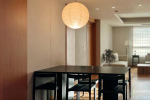 a black dining room table with chairs and a lamp at Gyeongbokgung Palace View, 3-min Walk to Gwanghwamun & Jonggak Stations in Seoul