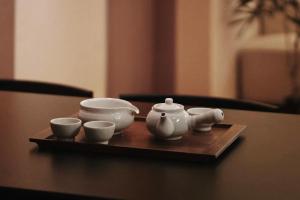 a tray with three tea pots and cups on a table at Gyeongbokgung Palace View, 3-min Walk to Gwanghwamun & Jonggak Stations in Seoul