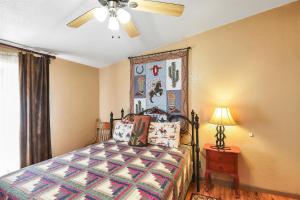 una camera da letto con un letto e un ventilatore a soffitto di Gorgeous Historic 3 BR Log Cabin w Forest Views 20 Minutes from Flagstaff Now with Wi-Fi a Parks