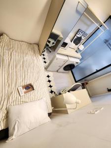 Una pequeña habitación con una cama y un televisor. en SNU Stay hostel, en Seúl