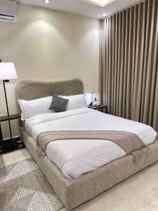 a bedroom with a large white bed with curtains at استديو رواق in Riyadh