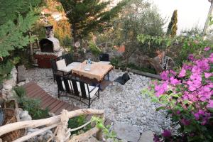 a table and chairs in a garden with flowers at Captain's View in Dobra Voda