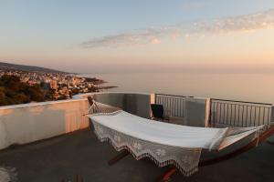 a hammock on the edge of a balcony overlooking a city at Captain's View in Dobra Voda