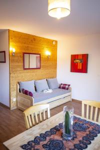 a living room with a couch and a table at Hameau 5 106b - SPA & PISCINE studio 4 pers in Orelle