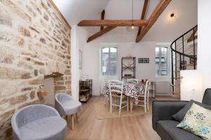 Una sala de estar con un sofá, una mesa y sillas. en Le Duplex entre terre et mer, en Auray