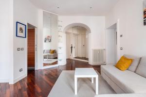 un soggiorno bianco con un divano e un tavolo di La corte di Merlino - Apt centrale di pregio a Roma