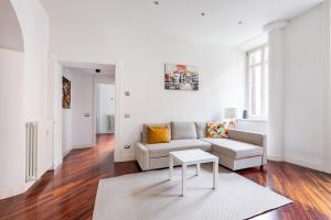 un soggiorno bianco con un divano e un tavolo di La corte di Merlino - Apt centrale di pregio a Roma