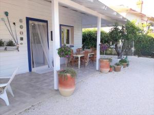 a patio with a table and chairs and potted plants at Gli Oleandri in Ginosa Marina