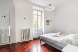 una camera da letto bianca con un letto e una finestra di La corte di Merlino - Apt centrale di pregio a Roma