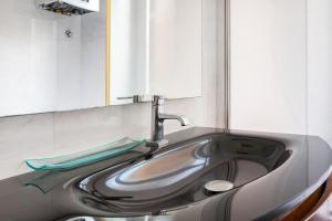 un bagno con lavandino e specchio di La corte di Merlino - Apt centrale di pregio a Roma Altre 19 foto