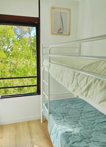 a bedroom with a bunk bed and a window at Casa do Sal in Troia +4 photos