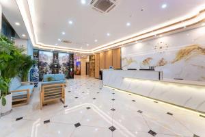 a lobby with a reception desk and chairs at 德州董子园风景区万信至格酒店 in Dezhou