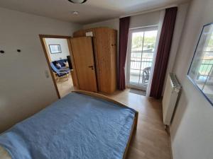 a bedroom with a bed and a room with a window at Fewo-32-Hauke in Orth +4 photos