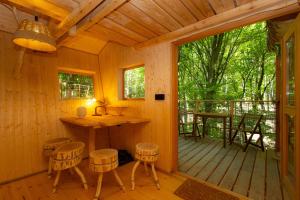 波切尼斯Treehouse Bojnice的一间带厨房和带凳子的门廊的小木屋