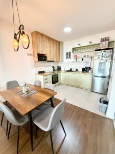 a kitchen with a wooden dining table and chairs at MML Apartment Skopje in Skopje +24 photos