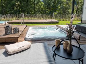a hot tub sitting on top of a wooden deck at ZeiTraum Ferienwohnung Rohrhardsberg in Elzach