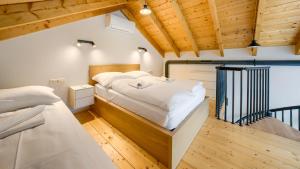 a bedroom with two beds and wooden ceilings at Inteligentne rubinowe domy z sauną, Sun & Snow in Grzybowo
