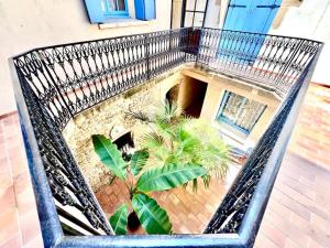 an empty metal chair with plants in a courtyard at Le Logis du Château , Charme au cœur de Sommières in Sommières