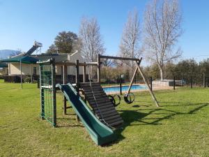 un parco giochi con scivolo accanto alla piscina di Rhodene Farm Cottages a Prince Alfreds Hamlet