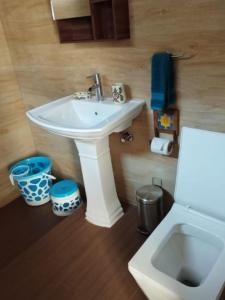Un baño con un lavabo blanco y un inodoro. en Rumis Mountain Sunset, en Nainital
