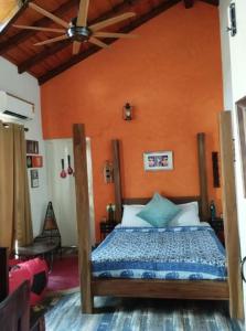 Un dormitorio con una cama con una pared naranja. en Rumis Mountain Sunset, en Nainital