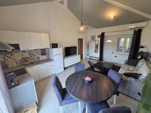 a kitchen and living room with a table and chairs at The Lovely Loft in Cres