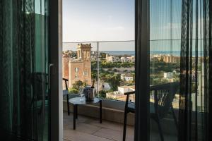 a balcony with a table and a view of a city at Hyatt Regency Malta in St. Julianʼs