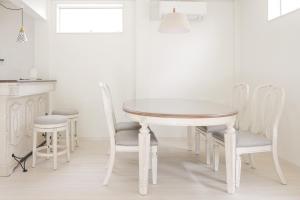 a white dining table and chairs in a kitchen at 静岡 伊豆高原 ペットと泊まれるプライベートヴィラ Tous les doudouトゥレ ドゥドゥ in Ito