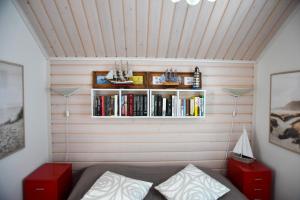 a room with a bed and a shelf with books at Ranta-Sumpun Helmi 10 Beach house with sauna in Hailuoto