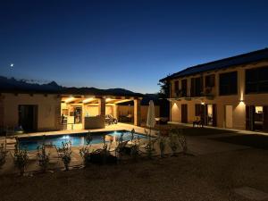 a house with a swimming pool at night at La Porta delle Meraviglie in Saluzzo