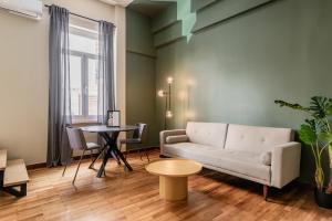 a living room with a couch and a table at The Gate by Zoia Living in Athens