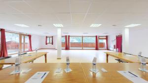 a large room with wooden tables and windows at Hameau 8 205 - SPA & PISCINE studio 4 pers in Orelle +10 photos