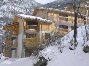 a large wooden building with snow on the ground at Hameau 8 205 - SPA & PISCINE studio 4 pers in Orelle