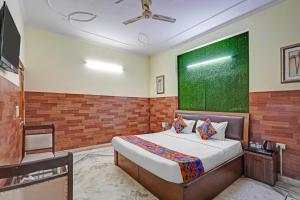 a bedroom with a bed and a green wall at FabHotel The Everest 43 in Noida +20 photos